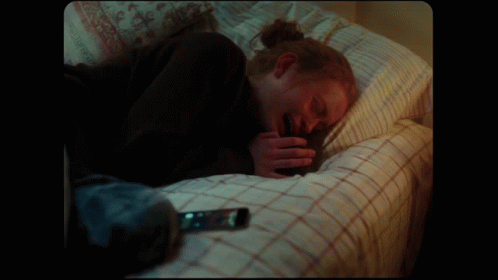 Person Lying on Bed with Cell Phone