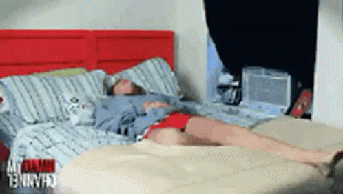 Person Lying on Bed with Red Headboard