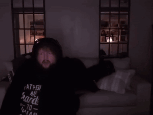 Person Lying on Couch in Dark Room