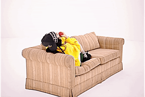 Person Lying on Couch in Yellow Jacket and Hat