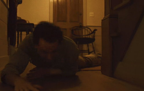 Person Lying on Wooden Floor With Arms Outstretched