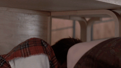 Person Lying Under Table With Head Down GIF