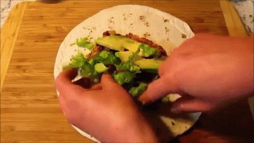 Person Making Tortilla With Lettuce Avocado And Meat GIF