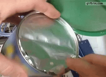 Person Opening Can With Magnifying Glass Gifbin