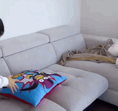 Person Placing Pillow on Couch with Cartoon Character