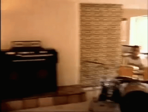 Person Playing Drums in Brick Wall Room