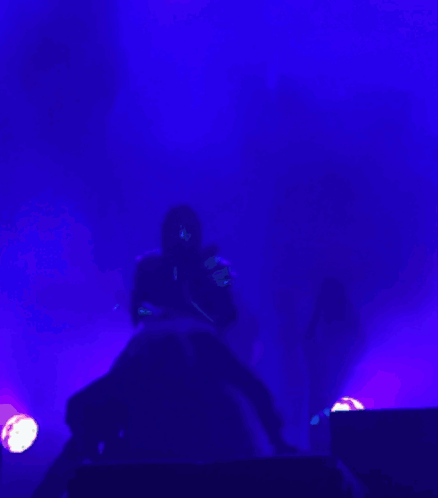 Person Playing Guitar in Dark Room With Purple Lights