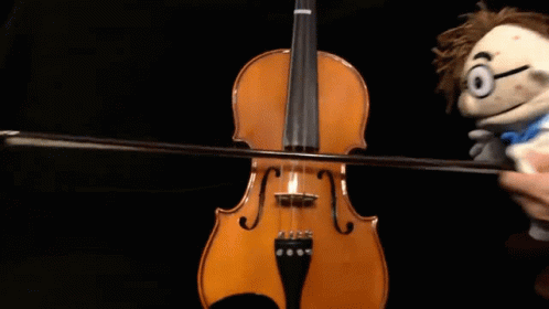 Person Playing Violin Next to Puppet