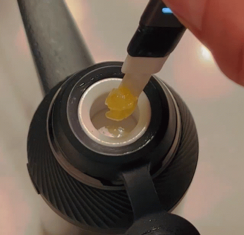 Person Plugging Charger Into Device With Yellow Substance