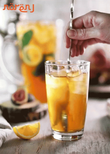 Person Pouring Drink Into Glass With Ice