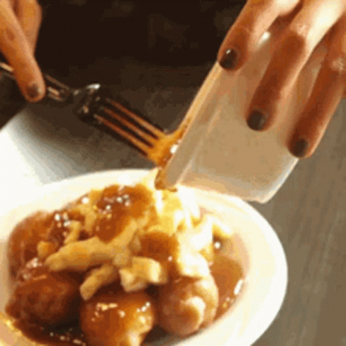 Person Pouring Gravy on Plate of Food