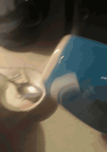 Person Pouring Into Glass With Blue Container