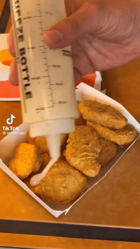 Person Pouring Sauce Into Chicken Nuggets GIF