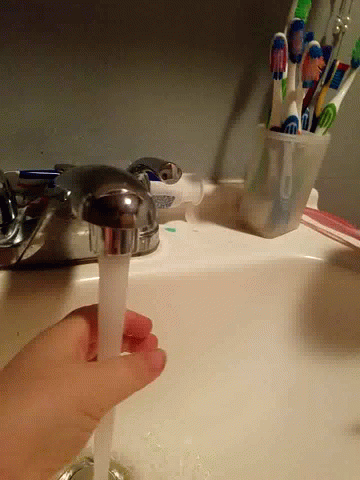 Person Pouring Toothpaste Into Faucet