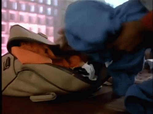 Person Putting Clothes in Suitcase
