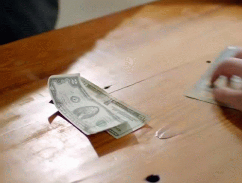 Person Putting Dollar Into Piggy Bank GIF