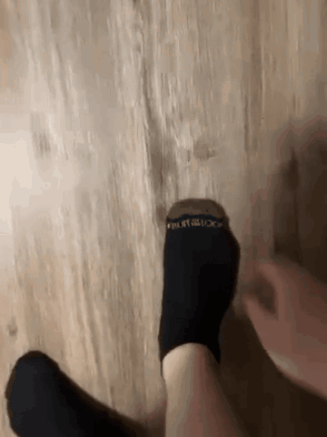 Person Putting On Black Socks Fruit of the Loom