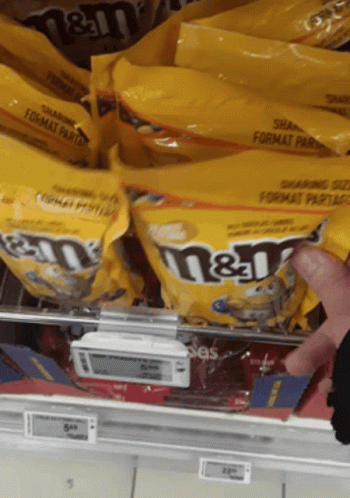 Person Reaching For Bag Of M&M's GIF