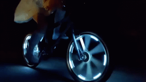 Person Riding Bicycle with Glowing Wheels at Night