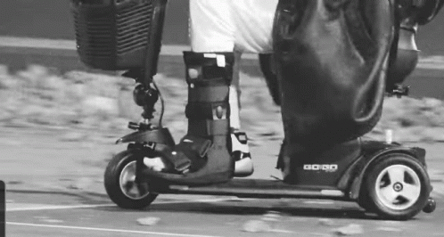 Person Riding Mobility Scooter In Black And White GIF