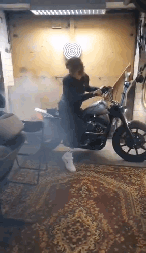 Person Riding Motorcycle in Garage With Smoke