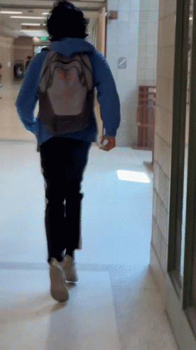 Person Running Down Hallway With Columbia Backpack