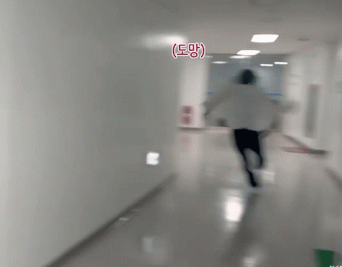Person Running Down Hallway With Eee Sign GIF