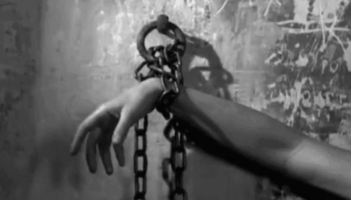 Person's Hand Chained To Wall GIF