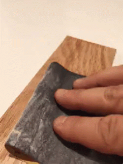 Person Sanding Wood with Fingers on Sandpaper