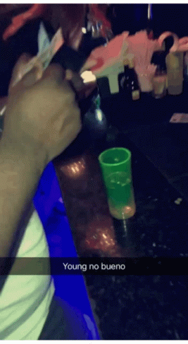 Person Sitting at Bar With Green Shot Glass