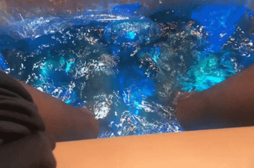 Person Sitting in Bathtub with Blue Water