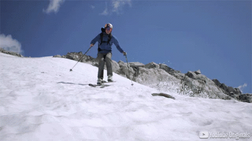 Person Skiing Down Snowy Mountain With YouTube Originals Logo