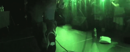 Person Standing at Microphone in Dark Room