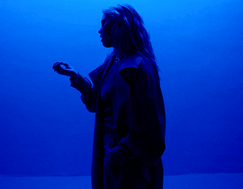 Person Standing Before Large Blue Light