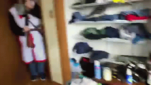 Person Standing in Closet With Clothes