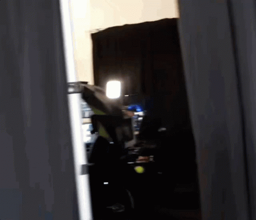 Person Standing In Dark Room With Light GIF