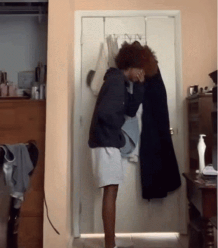 Person Standing in Front of Door With Clothes Hanging