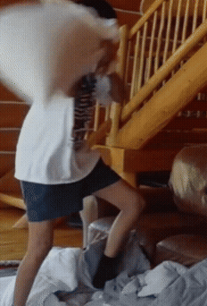 Person Standing On Bed With Pillow On Back GIF