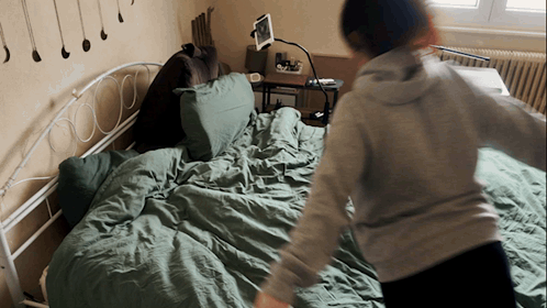 Person Standing On Bed With Tablet GIF