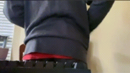 Person Standing On Chair With Outstretched Arms In Red Shirt GIF