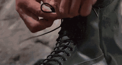 Person Tying Shoelaces On Black Boots GIF