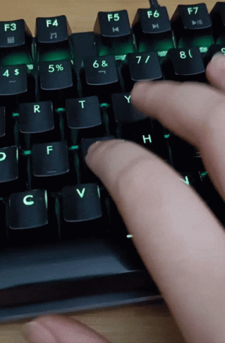 Person Typing on Keyboard With Green Light Behind F5 and F6