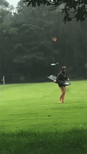 Person Walking on Green Field With Skateboard