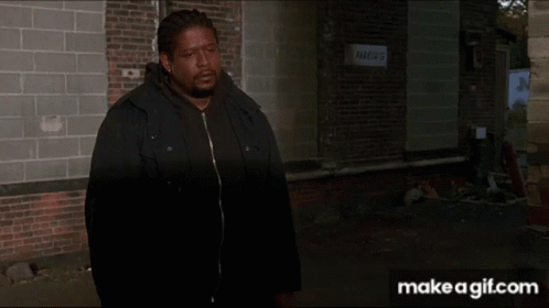 Person Walking Past Brick Building With Parking Sign