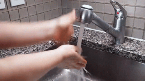 Person Washing Hands at Sink With Red Button