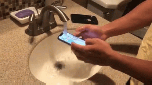 Person Washing Hands While Holding Phone