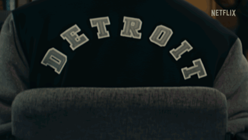 Person Wearing Detroit Varsity Jacket With Netflix Logo