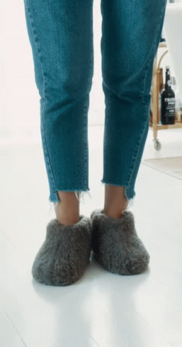 Person Wearing Grey Slippers With Evian Bottle GIF
