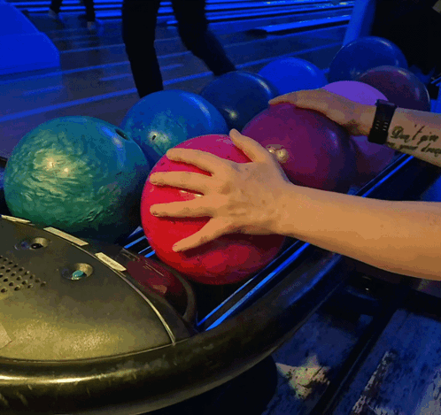 Person With Arm Tattoo Putting Bowling Ball