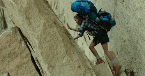 Person With Blue Backpack Climbing Rock Wall GIF